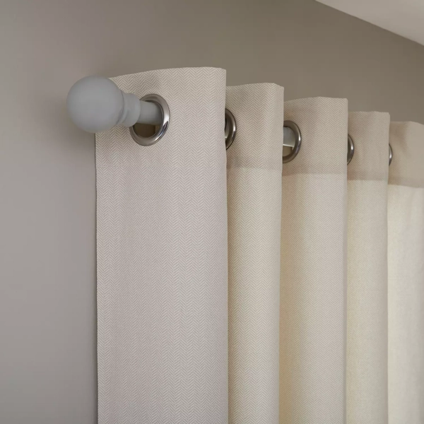 Close-up of cream chevron eyelet curtains on a rod