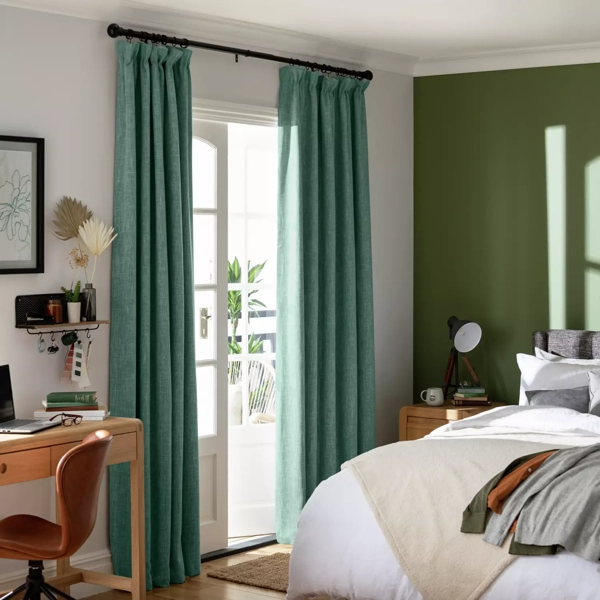 Modern bedroom with teal curtains and green accent wall