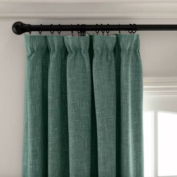 Teal pinch pleat curtains on a black rod